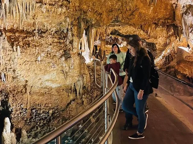 Tourists walking on a pathway inside Luray Caverns admiring rock formations.